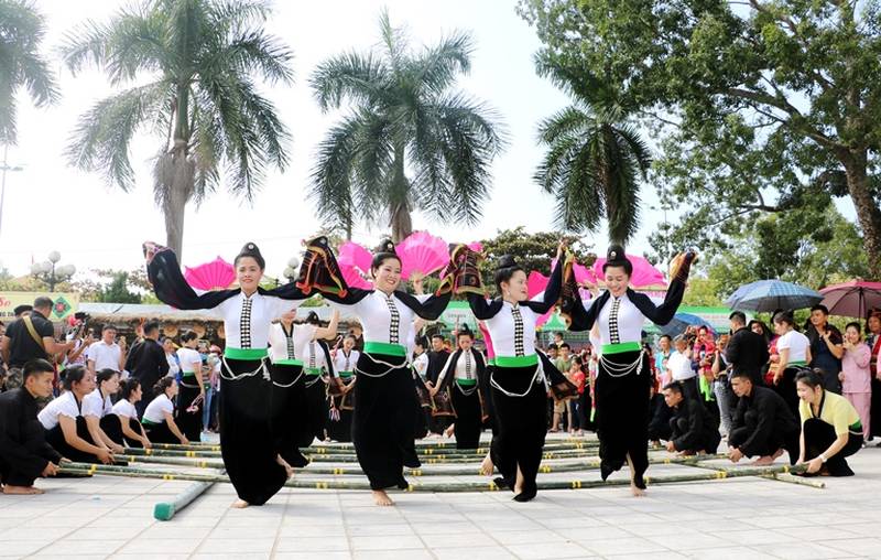 Local residents guide tourists in participating in the bamboo pole dance Local residents guide tourists in participating in the bamboo pole dance