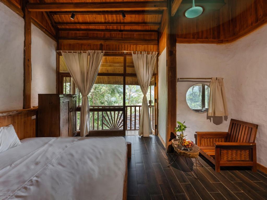 Phòng nghỉ tại Ké Retreat với nội thất gỗ giản dị, giường ngủ ấm cúng và ban công thoáng đãng Phòng nghỉ tại Ké Retreat với nội thất gỗ giản dị, giường ngủ ấm cúng và ban công thoáng đãng