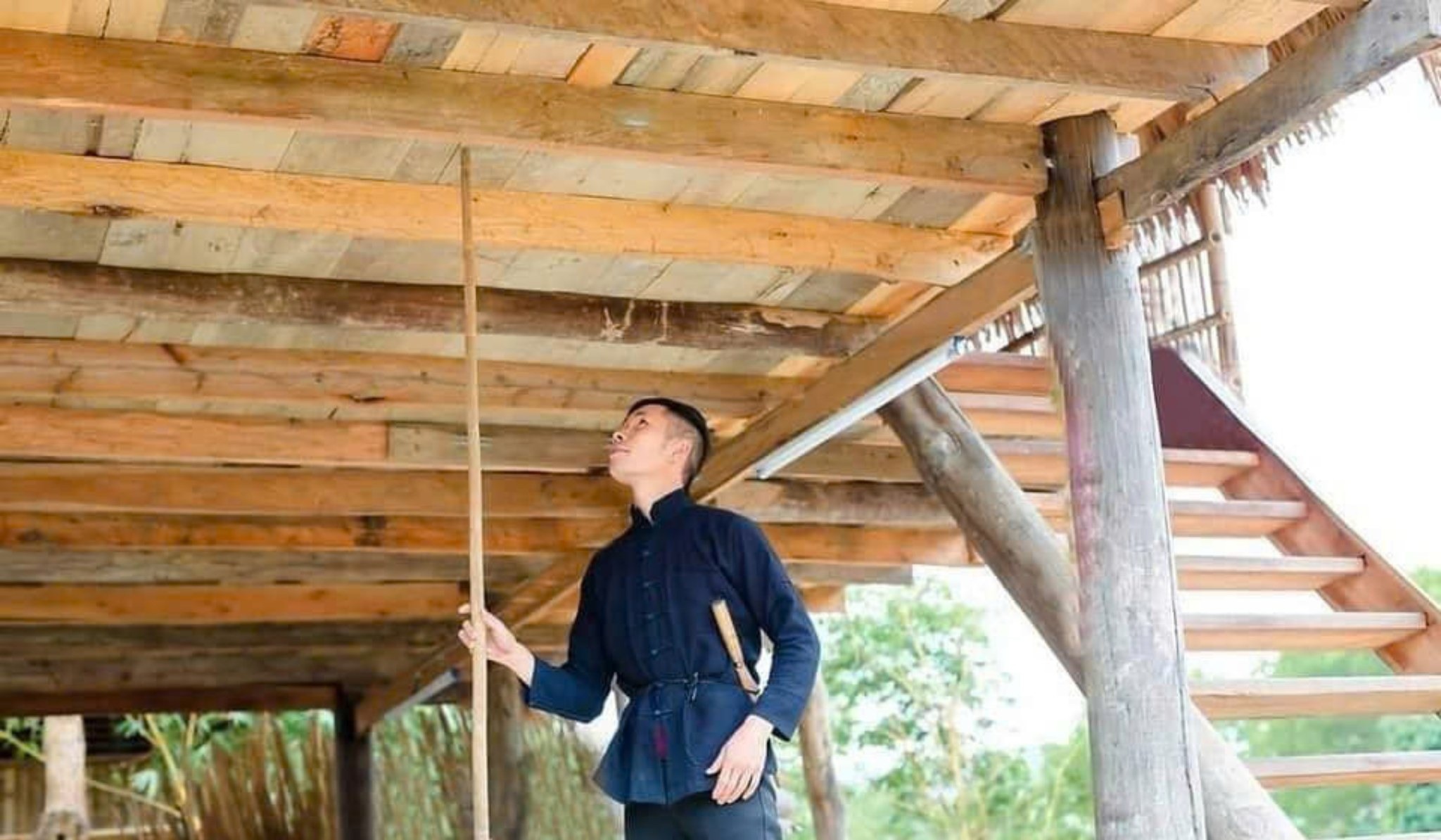 Chàng trai dùng cây gậy gõ hoặc chọc lên sàn nhà nơi cô gái đang nằm ngủ Chàng trai dùng cây gậy gõ hoặc chọc lên sàn nhà nơi cô gái đang nằm ngủ